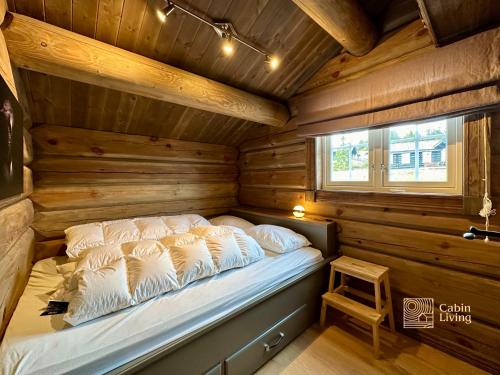 a bedroom with a bed in a wooden cabin at Newer lovely cabin in Birkebeinerbakken Sjusjøen in Ringsaker