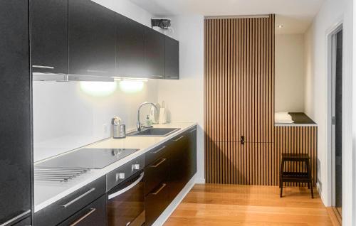 a kitchen with black cabinets and a sink at Beautiful Apartment In Ebeltoft in Ebeltoft