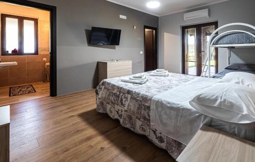 a bedroom with a large bed and a bathroom at Pet Friendly Home In Torchiara in Torchiara