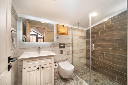a bathroom with a toilet and a sink and a shower at Orange Garden Hotel Akyaka in Akyaka