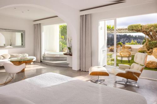 a bedroom with a bed and a table and chairs at Hacienda Na Xamena, Ibiza in Na Xamena