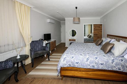 a bedroom with a bed and a desk and a chair at Dusler Vadisi Kazdaglari in Edremit