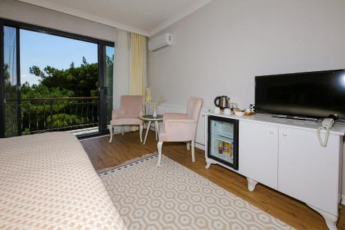 a living room with a flat screen tv on a cabinet at Dusler Vadisi Kazdaglari in Edremit