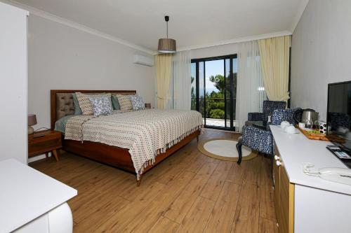 a bedroom with a bed and a desk with a television at Dusler Vadisi Kazdaglari in Edremit