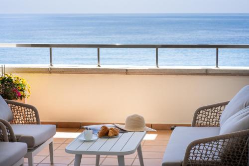stół z kapeluszem na balkonie z widokiem na ocean w obiekcie Front line beach luxury apartment in Heaven Beach w mieście Estepona