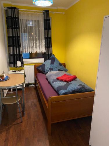 a small bedroom with a bed and a table at Pension am Bahnhof in Fürstenwalde