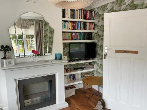 a living room with a fireplace and a mirror at Frinton45 in Frinton-on-Sea