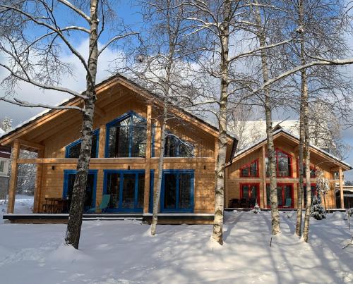 a log home in the snow with trees at Chalets Buky in Tatranská Lomnica