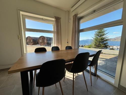 a dining room with a table and chairs and a large window at Sleeping barrel lodge Smaken av Ryfylke Event AS, drives ikke som hotell in Hjelmeland
