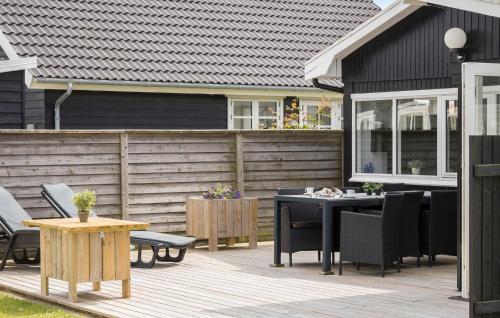 a wooden deck with a table and chairs on a house at Gorgeous Home In Otterup With Wifi in Otterup