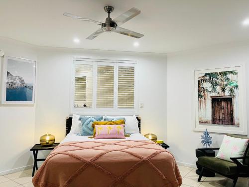 a bedroom with a bed and a ceiling fan at Ocean View Island 2-bedroom Townhouse Buggy Valet service extra Queen air bed in Hamilton Island