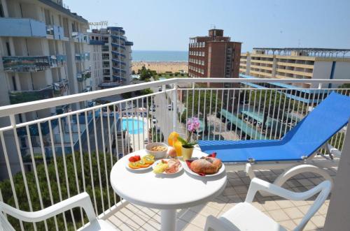 a plate of food on a table on a balcony at Hotel Luna in Bibione