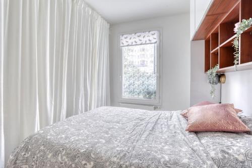a white bedroom with a bed and a window at EDEN Home in Bezons