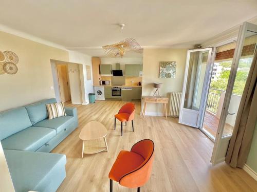 - un salon avec un canapé bleu et des fauteuils orange dans l'établissement Spacieux T3 terrasse vue mer, à Sète