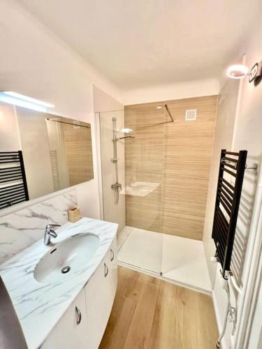 une salle de bain blanche avec un lavabo et une douche dans l'établissement Spacieux T3 terrasse vue mer, à Sète