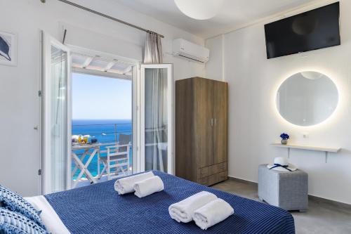 een slaapkamer met een blauw bed en uitzicht op de oceaan bij Sea View Studios in Skopelos Town