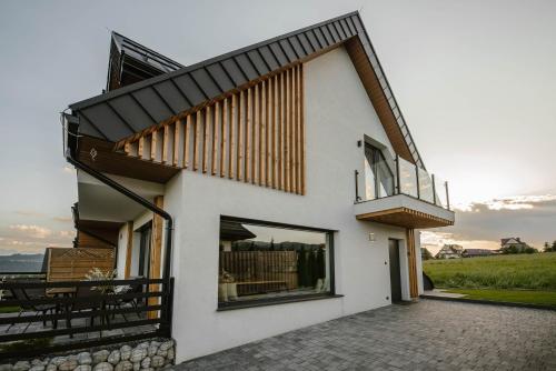 a white house with a balcony and a patio at To Je To apartamenty in Maniowy