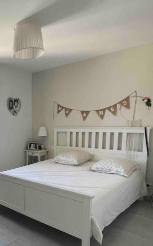 - une chambre blanche avec un lit blanc et une tête de lit dans l'établissement Maison familiale avec piscine sans vis à vis, à Béziers