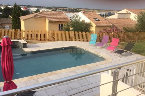 une piscine avec des chaises et une clôture dans l'établissement Maison familiale avec piscine sans vis à vis, à Béziers