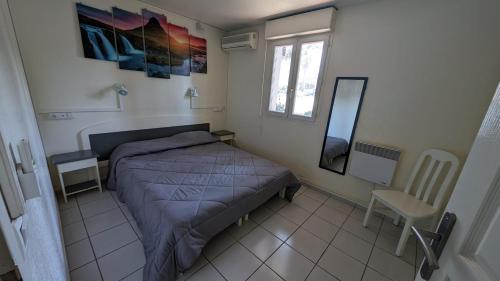 une chambre avec un lit, une chaise et un miroir dans l'établissement Joli T2 - Emeraude 28, à Canet