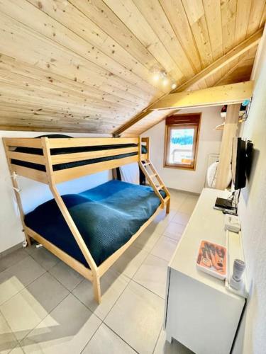 une chambre avec un lit superposé et un bureau dans l'établissement La TANIÈRE du LOUP, à Saint-Étienne-en-Dévoluy
