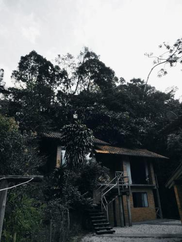 a house with a staircase leading up to it at Suíte com cachoeira no quintal in Antônio Carlos