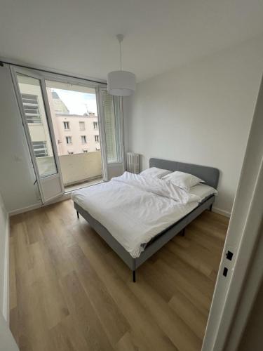 une chambre avec un lit et une grande fenêtre dans l'établissement EXCEPTIONNEL - Appartement près TOUR EIFFEL, à Paris