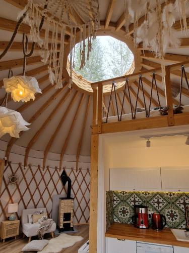 a room with a large wooden ceiling with a window at Osada JurtCamp w Witowie in Witówko