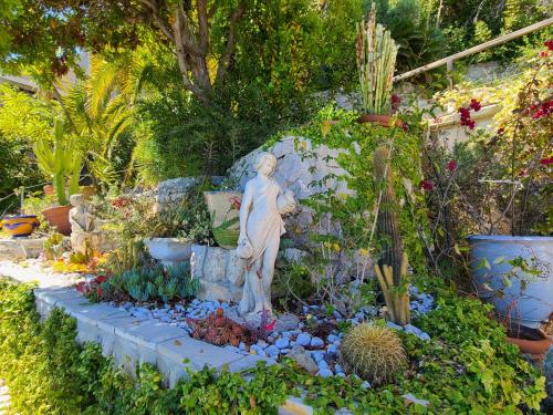 a statue of a woman in a garden with plants at Eze sur mer - vue Saint Jean Cap Ferrat in Èze