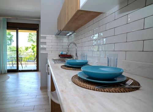 a kitchen with blue bowls and plates on a counter at Homelia in Limenaria