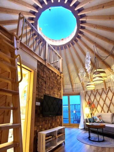 a living room with a ceiling with a large window at Osada JurtCamp w Witowie in Witówko