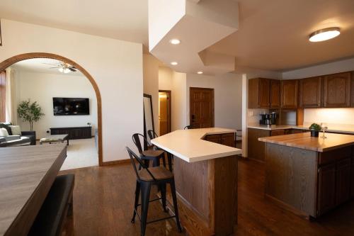 an open kitchen and living room with a counter and chairs at Villager Loft Pool Table & Dining Discounts in Charlevoix