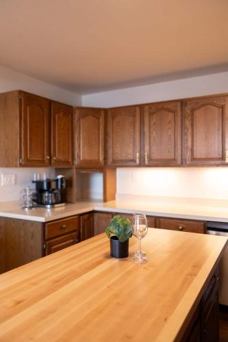 a kitchen with a wooden table with a wine glass at Villager Loft Pool Table & Dining Discounts in Charlevoix