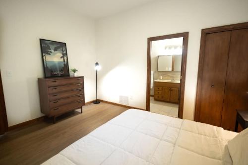 a bedroom with a bed and a dresser and a mirror at Villager Loft Pool Table & Dining Discounts in Charlevoix