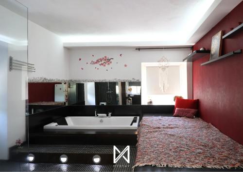 ein Badezimmer mit einer Badewanne und einer roten Wand in der Unterkunft MyStay - Colina da Felicidade in Esposende