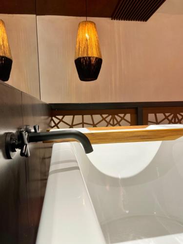 a wooden surfboard hanging from a wall with lights at VILLA MERIDA BOUTIQUE HOTEL - Adults Only in Mérida