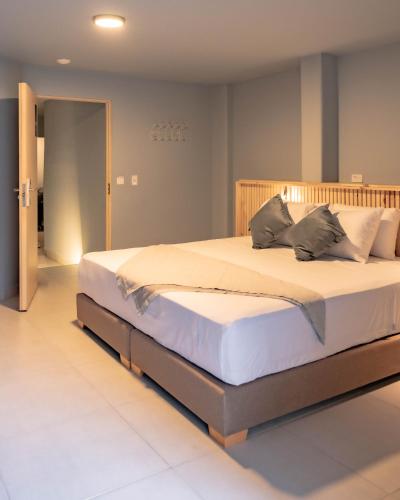 a bedroom with a large bed with white sheets and pillows at Leviu by Bernalo Hotels in Medellín