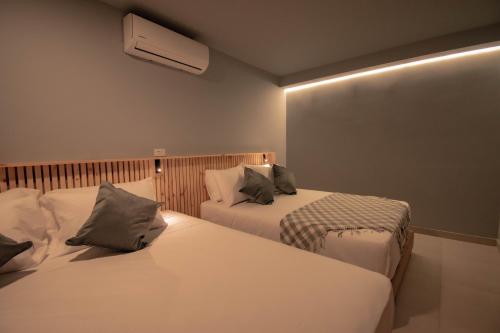 a hotel room with two beds and a air conditioner at Leviu by Bernalo Hotels in Medellín