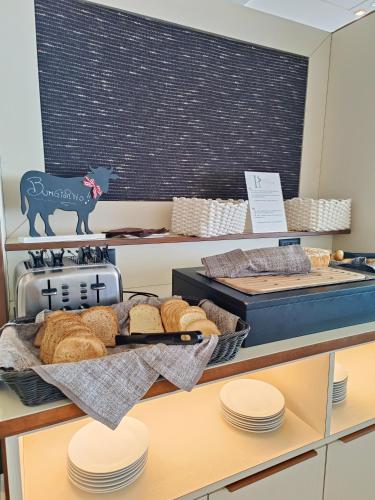 a table with bread and a chalkboard with a cow on it at Hotel President in Prato