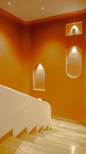 a room with orange walls and wooden floors at Leviu by Bernalo Hotels in Medellín