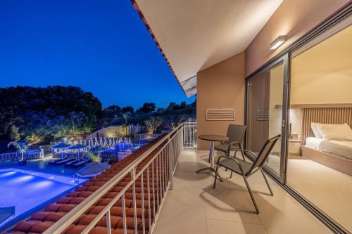 a balcony with a view of a pool and a bedroom at The "L" Suites & Apartments in Argostoli