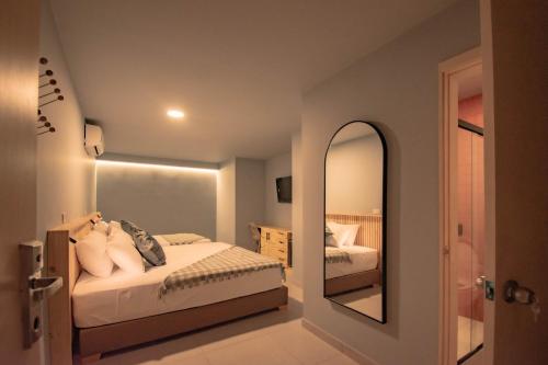 a bedroom with a bed and a mirror at Leviu by Bernalo Hotels in Medellín