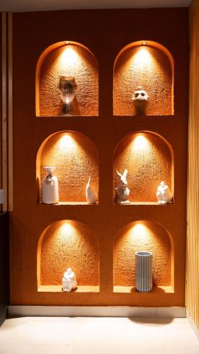 a shelf with dishes and vases on it with lights at Leviu by Bernalo Hotels in Medellín