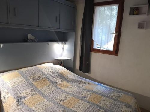 une chambre avec un lit et une fenêtre dans l'établissement Agréable pavillon T3 Gruissan, à Gruissan