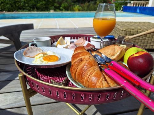 a basket of breakfast food and a glass of orange juice at Villa Sisyphe chambre"la jeanette" in Le Thoronet