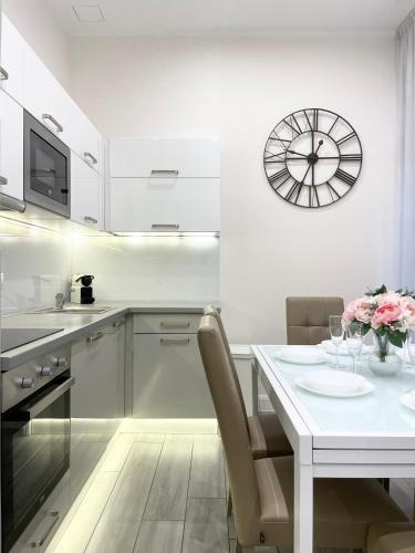 a kitchen with a table and a clock on the wall at Trigon Palace in Budapest