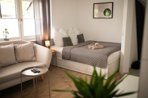 a small bedroom with a bed and a couch at HUGOS Studio Apartment in Wiesloch