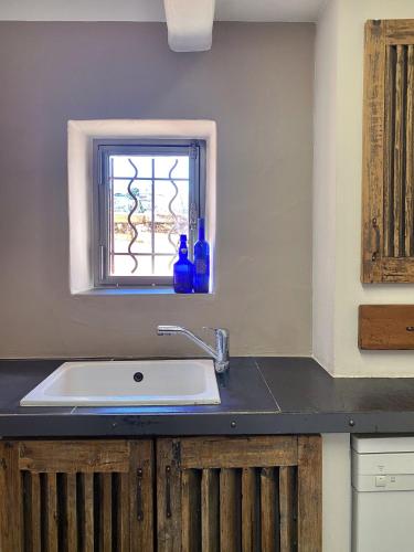 un comptoir de cuisine avec un évier et une fenêtre dans l'établissement Maison atypique proche Luberon et Avignon, à Châteauneuf-de-Gadagne