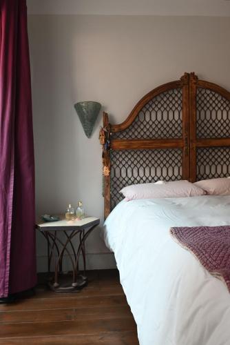 une chambre avec un lit et une table de chevet dans l'établissement Maison atypique proche Luberon et Avignon, à Châteauneuf-de-Gadagne