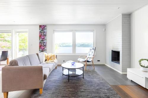 uma sala de estar com um sofá e uma mesa em The Luxurious Lakeview Villa near Stockholm em Estocolmo